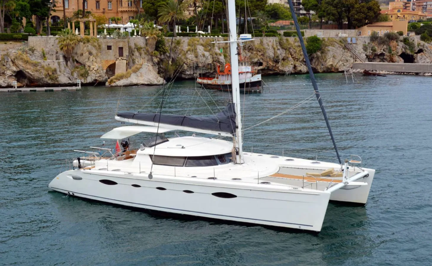 Catamarano di lusso in navigazione lungo la costa